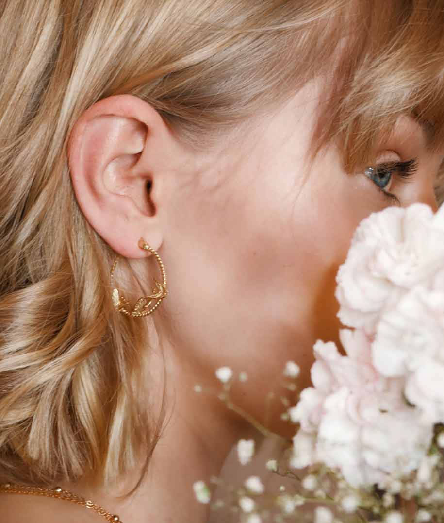 A woman hides behind a flower.